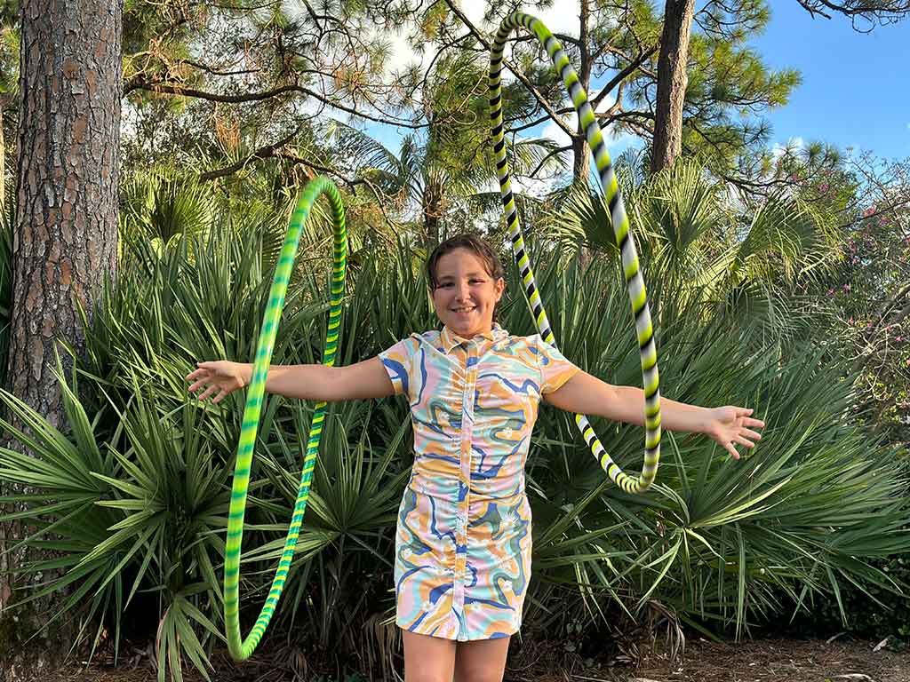 Young person twirling hoops on arms