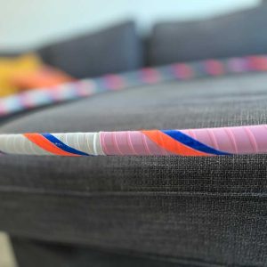 Multicolored hoop with patches of sold white, pink and blue, with stripes of day-glow orange and blue
