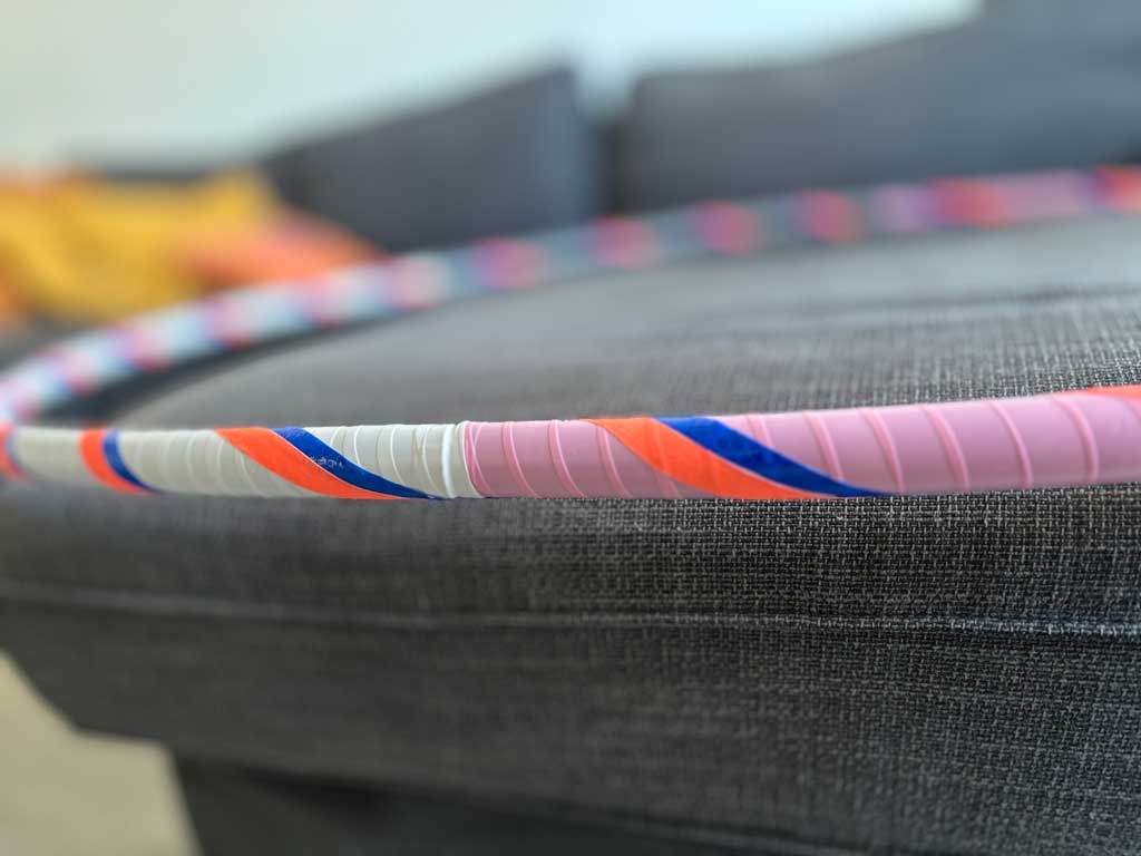 Multicolored hoop with patches of sold white, pink and blue, with stripes of day-glow orange and blue